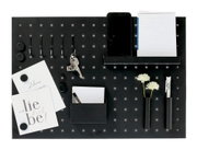 Schwarzes Memoboard mit Utensilien aus der Vogelperspektive, inklusive Haken, Notizblock, Smartphone-Halter, Stifthalter und dekorativen Elementen.