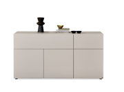Modernes, griffloses Sideboard in hellem Greige mit geometrisch aufgeteilten Fronten und dekorativen Accessoires, frontal aus leichter Obersicht dargestellt.