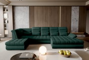Modernes, dunkelgrünes U-förmiges Ecksofa mit gepolsterter, gesteppten Sitzfläche und verstellbaren Rückenlehnen in einem stilvollen Wohnzimmer; frontale Perspektive auf das Sofa.