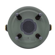 Unteransicht eines runden, grünen Geräts mit vier schwarzen Standfüßen und einem zentralen Lautsprechergitter.