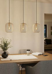 Drei moderne Pendelleuchten ROMAZZINA in einem Esszimmer, aus Holzlamellen gefertigt, mit warmem Licht, über einem Esstisch hängend. Perspektive: Frontalansicht.