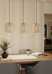 Drei moderne Pendelleuchten ROMAZZINA in einem Esszimmer, aus Holzlamellen gefertigt, mit warmem Licht, über einem Esstisch hängend. Perspektive: Frontalansicht.