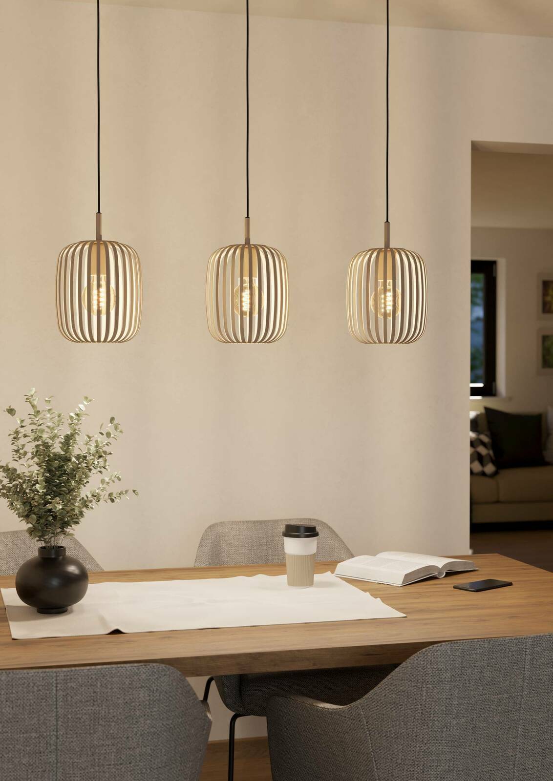 Drei moderne Pendelleuchten ROMAZZINA in einem Esszimmer, aus Holzlamellen gefertigt, mit warmem Licht, über einem Esstisch hängend. Perspektive: Frontalansicht.