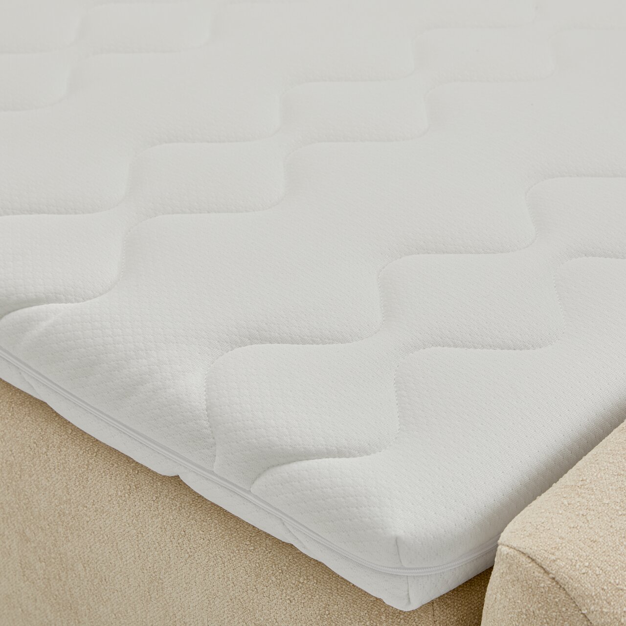 Nahaufnahme eines Boxbetts mit weißem, strukturiertem Matratzenbezug in seitlicher Perspektive.