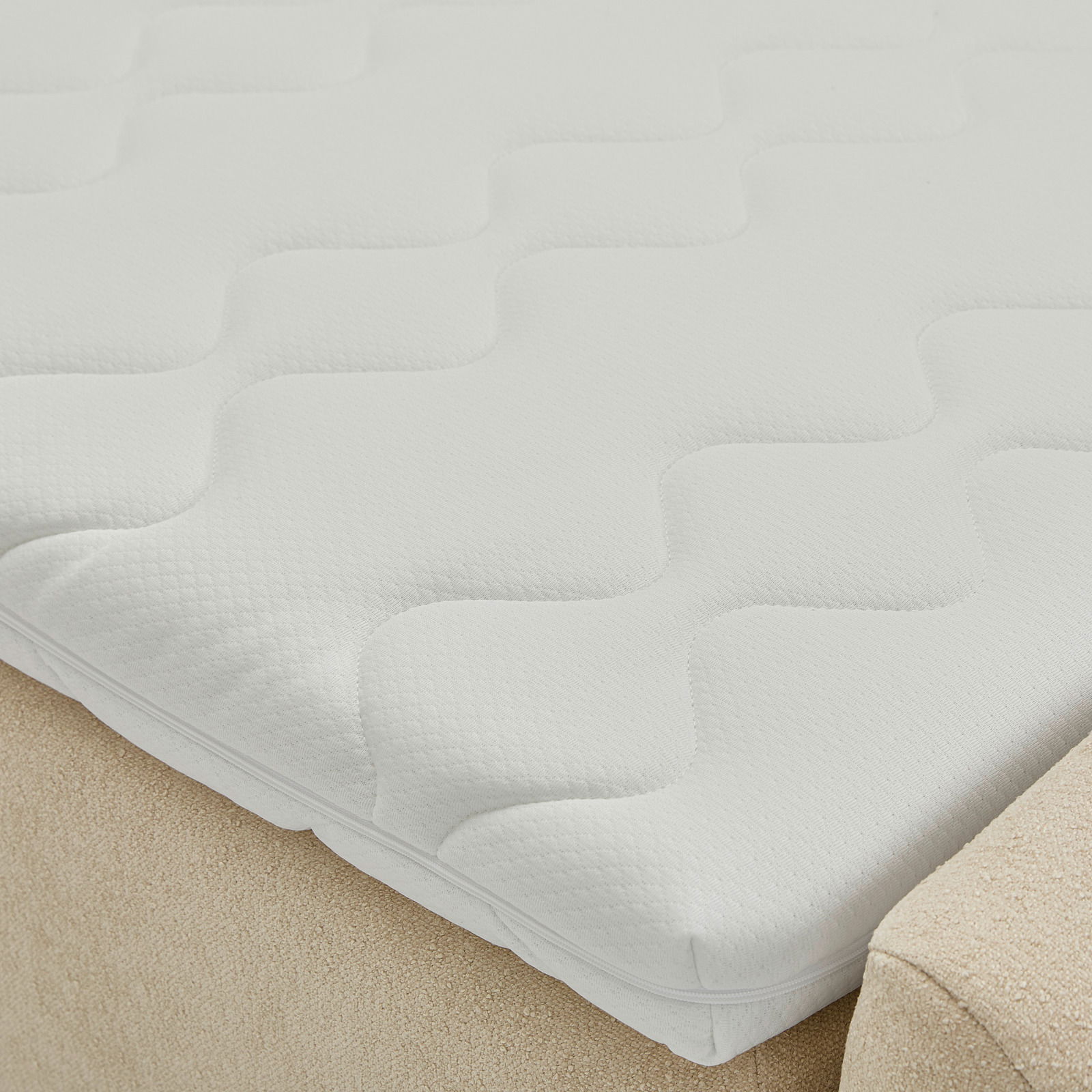 Nahaufnahme eines Boxbetts mit weißem, strukturiertem Matratzenbezug in seitlicher Perspektive.