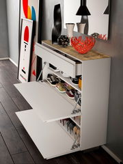 Moderner Hängeschuhschrank mit zwei Klappen und einer Schublade, gefüllt mit verschiedenen Schuhen, aus seitlicher Perspektive fotografiert.