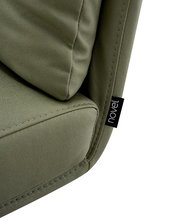 Nahaufnahme eines grünen Stuhls mit weicher Polsterung und einem Etikett mit der Aufschrift 'novel'.