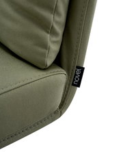 Close-up van een groene stoel met zachte bekleding en een label met het opschrift 'novel'.