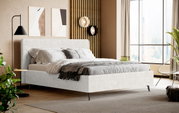 Modernes Polsterbett in hellgrauem Stoffbezug mit gepolstertem Kopfteil und schlanken schwarzen Metallfüßen, bezogen mit grauer Bettwäsche und Decke, in einem stilvollen Schlafzimmer – Perspektive: frontale 3/4-Ansicht von schräg vorn.