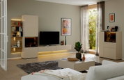 Modern modulair tv-meubel in beige en houtlook met vitrinekasten, wandplanken en sfeervolle ledverlichting, vanuit schuin vooraanzicht in een lichte woonkamer