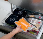 Vakuumier-Set EASYFRESH in einer Küchenschublade, mit vakuumierten Lebensmitteln wie Karotten und Brötchen, aus der Vogelperspektive betrachtet.