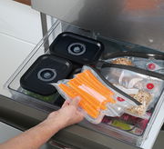 Vakuumier-Set EASYFRESH in einer Küchenschublade, mit vakuumierten Lebensmitteln wie Karotten und Brötchen, aus der Vogelperspektive betrachtet.