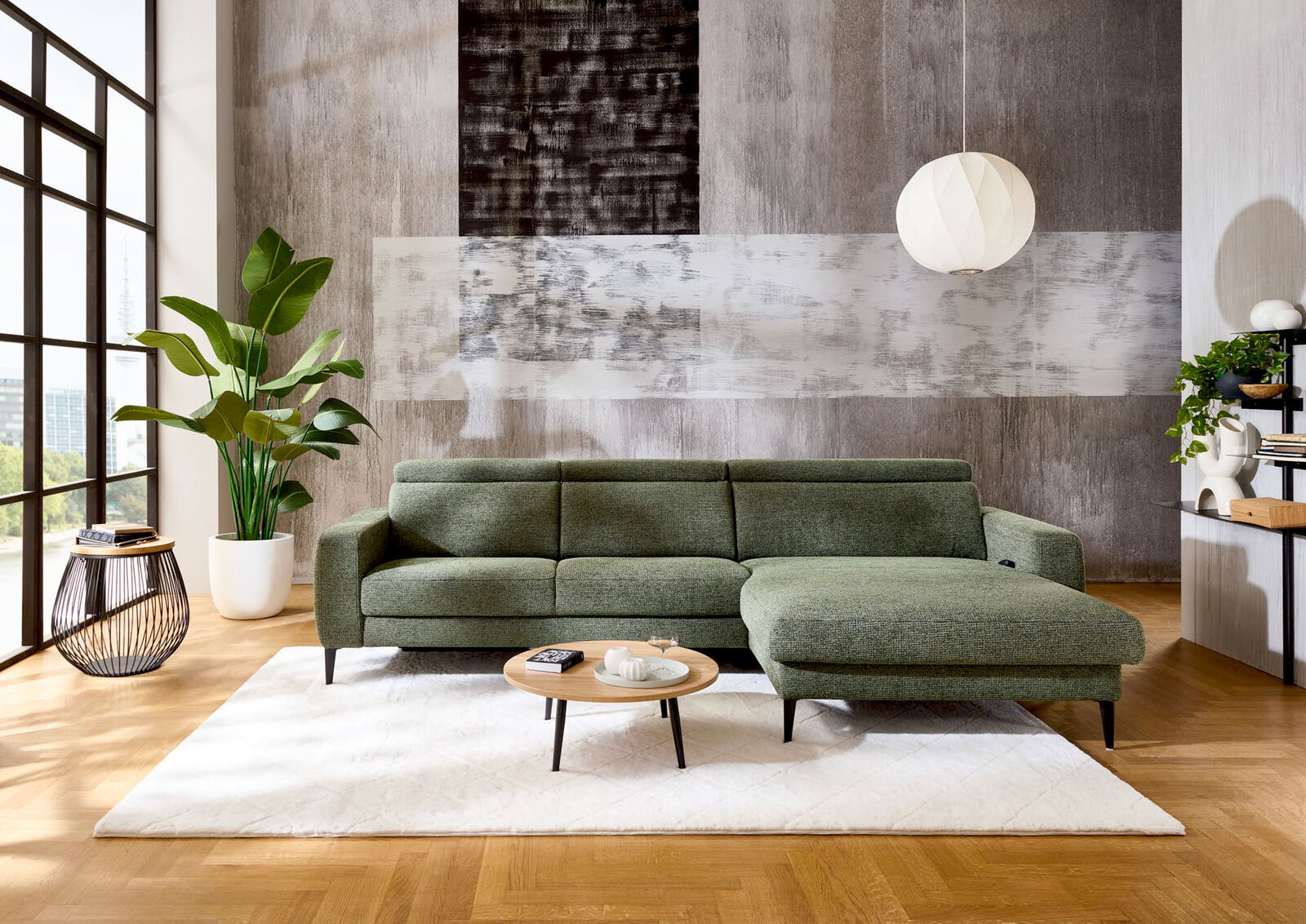 Grüne Longchairkombination in modernem Wohnzimmer, frontal fotografiert, mit großen Fenstern, Pflanzen und stilvollen Dekorationen.