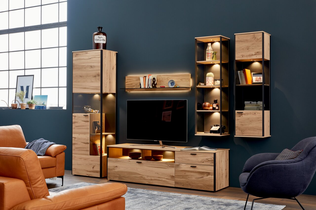 Schöner Wohnen Wandcombinatie ANDRA Moderne Wandkombination aus Holz mit integrierter Beleuchtung, bestehend aus mehreren Schränken und Regalen, frontal betrachtet.
