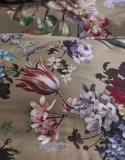 Nahaufnahme von Bettwäsche mit floralem Muster in verschiedenen Farben auf einem beigen Hintergrund.