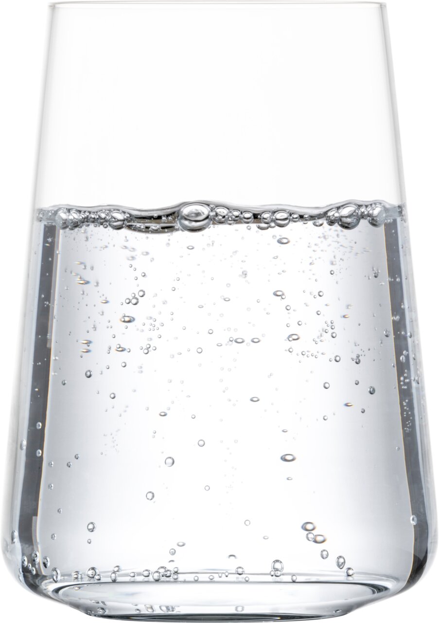 Nahaufnahme eines transparenten Trinkglases mit kohlensäurehaltigem Wasser, seitliche Perspektive