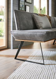 Detailansicht einer modernen Eckbank mit grauem Polster und schwarzem Metallgestell, seitliche Perspektive.