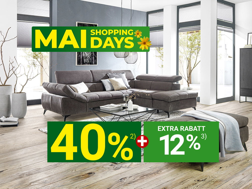 Modernes Wohnzimmer mit grauer Eckcouch, Couchtisch und Teppich, beworben mit „Mai Shopping Days“