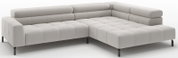 Lichtgrijze L-vormige hoekbank met chaise longue rechts, gecapitonneerde zitting en rugkussens en zwarte metalen poten, schuin van voren gefotografeerd