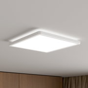 Quadratische, flache LED-Deckenleuchte mit weißem Rahmen und diffuser Lichtfläche, an der Zimmerdecke montiert, Ansicht schräg von unten