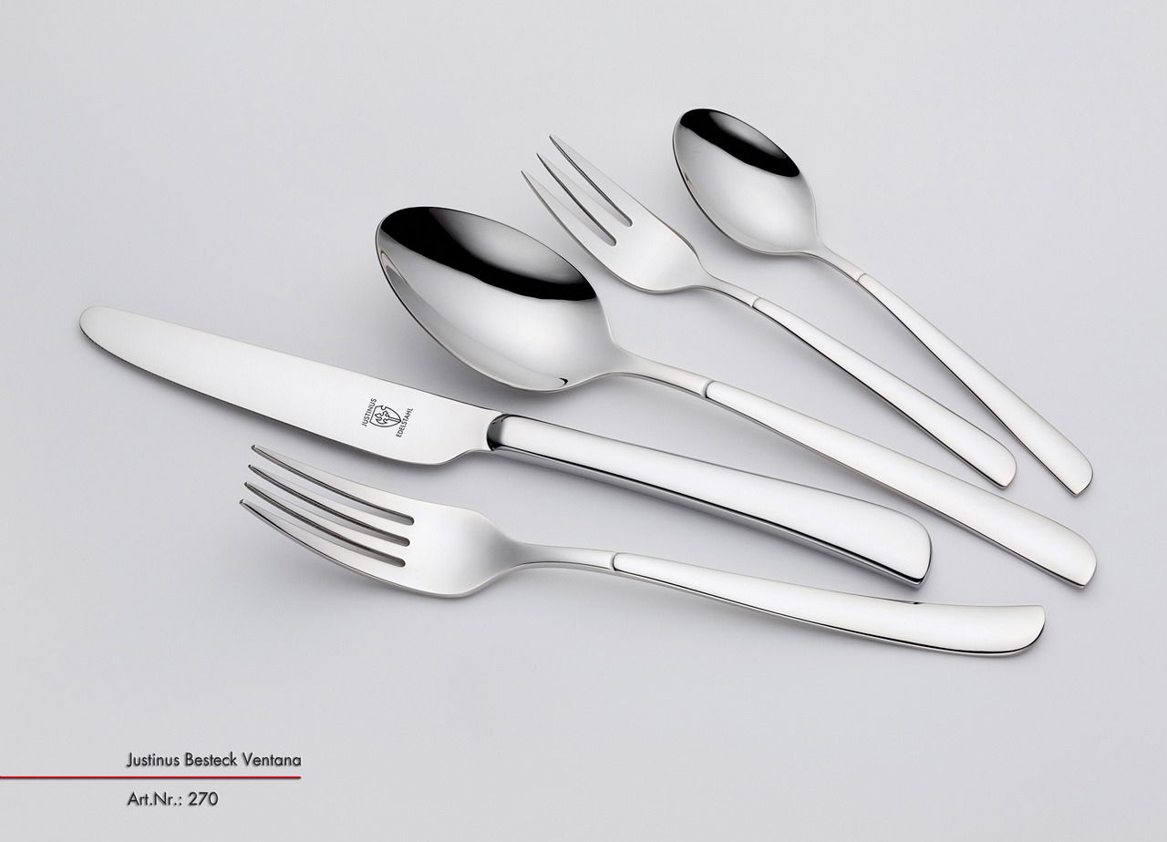 Set aus poliertem Besteck, bestehend aus Messer, Gabel, Löffel und Teelöffel, in seitlicher Perspektive.