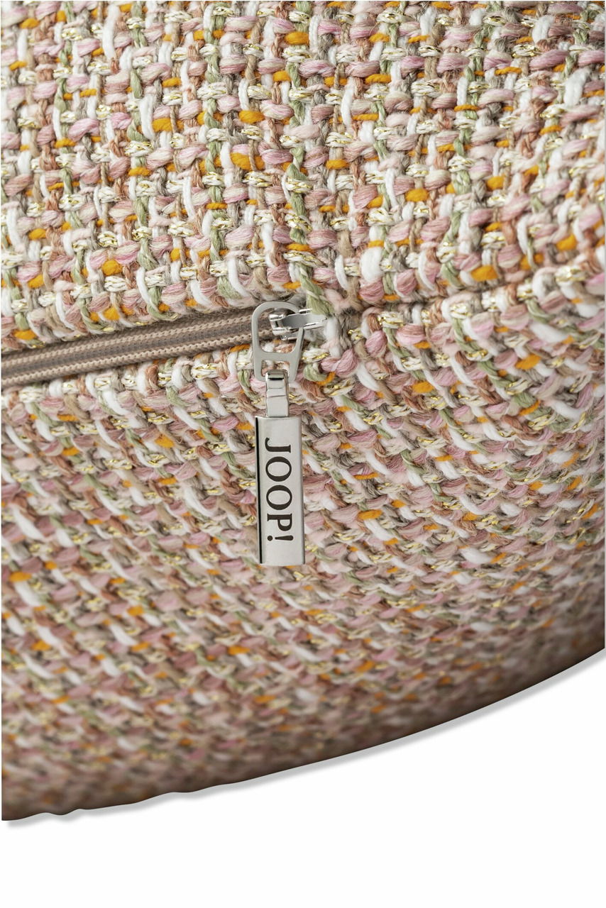Nahaufnahme einer Zierkissenhülle mit grobem, mehrfarbigem Gewebe und einem Reißverschluss mit JOOP!-Logo.