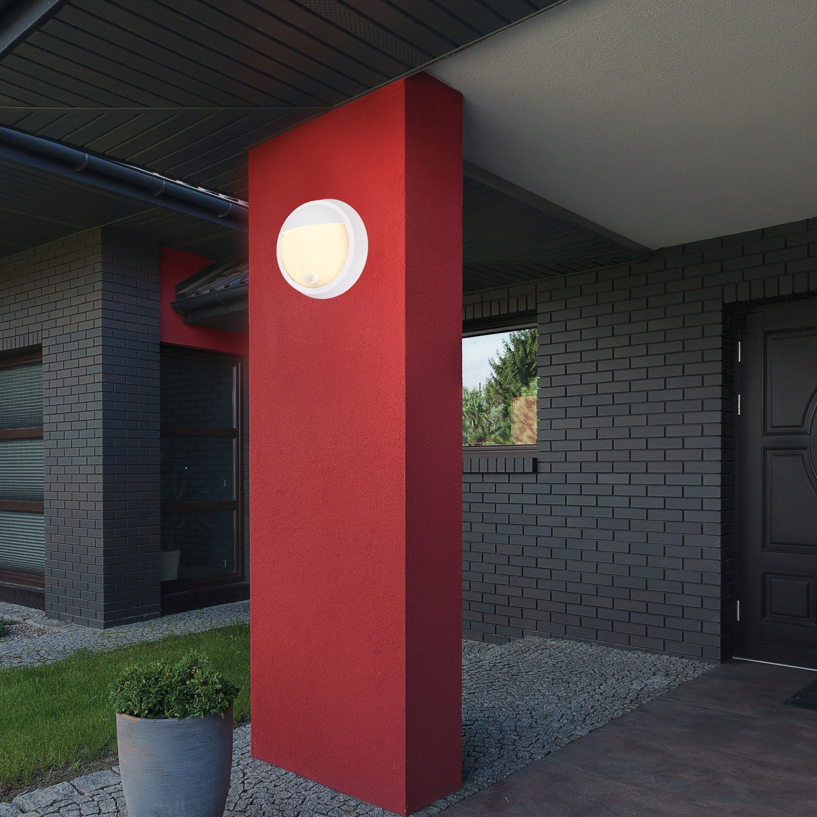 Briloner Akku-Außenwandleuchte Moderne Akku-Außenwandleuchte an einer roten Säule, seitliche Perspektive