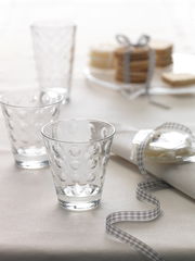 Trinkglas Optic 215ml mit gepunktetem Design, auf einem Tisch mit Serviette und Keksen, seitliche Perspektive