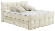 Beiges Boxspringbett mit gepolstertem Kopfteil und mehreren Kissen, seitliche Perspektive