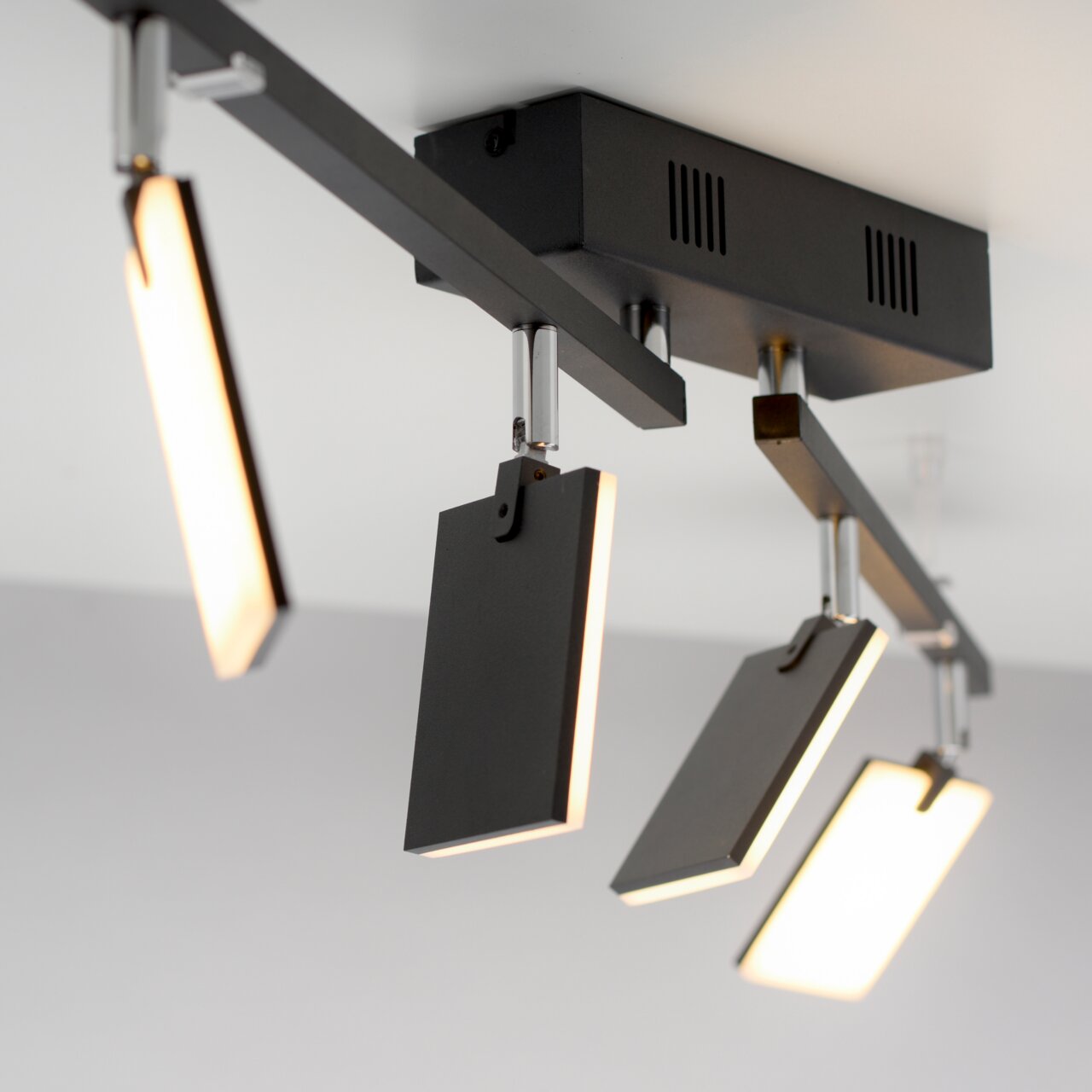 Moderne Deckenleuchte PURE MIRA von Paul Neuhaus mit drei rechteckigen, schwenkbaren Leuchtelementen in schwarzem Design, seitliche Perspektive.