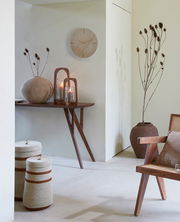 Wanduhr aus Holz in einem stilvoll eingerichteten Raum, seitliche Perspektive