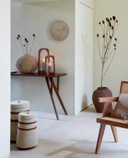 Houten wandklok in een stijlvol ingerichte kamer, zijaanzicht