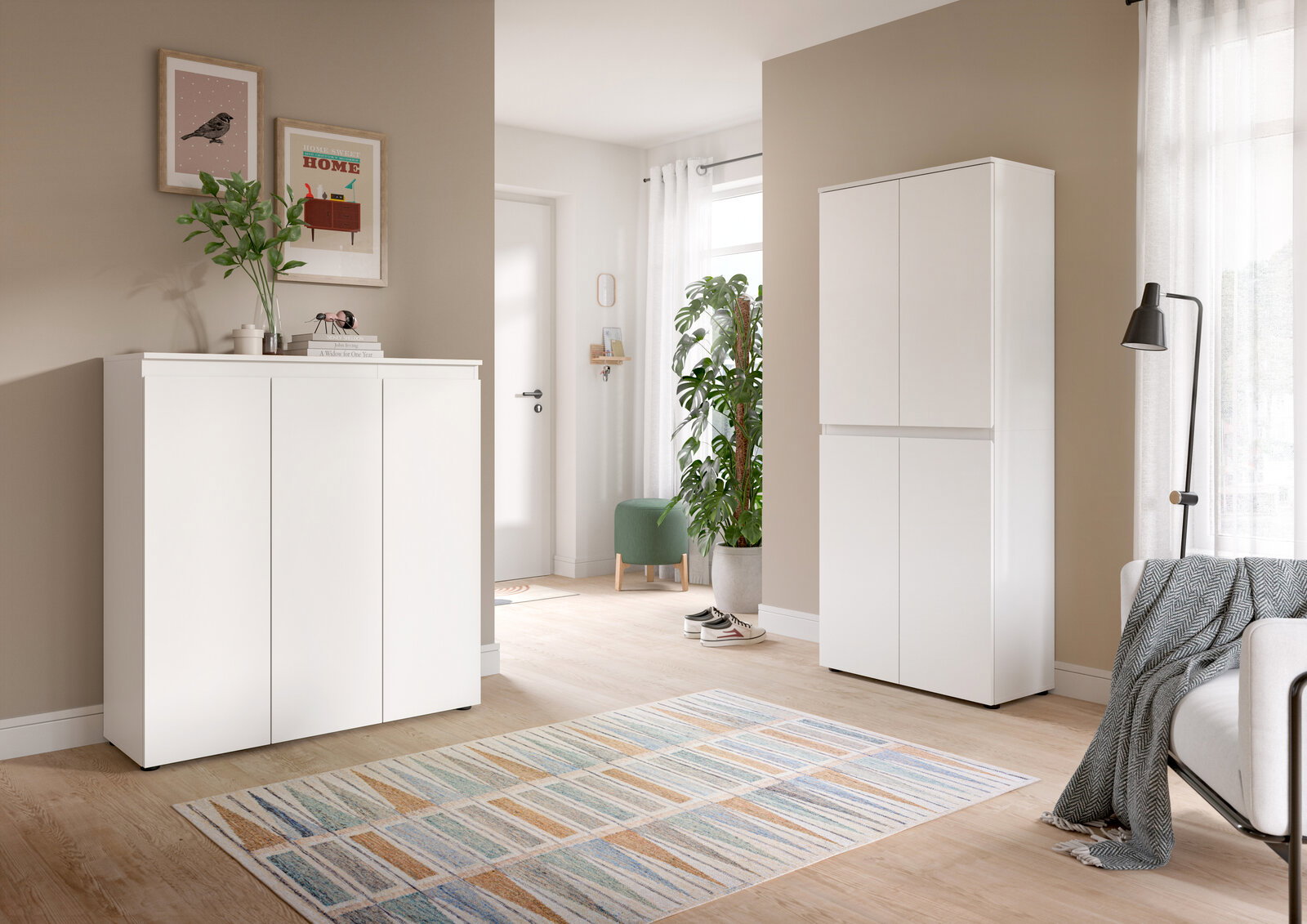 Heller Wohnraum mit zwei weißen, minimalistischen Schränken (links Sideboard, rechts hoher Schrank) vor beigen Wänden, aufgenommen in leichter Schrägansicht von vorn.