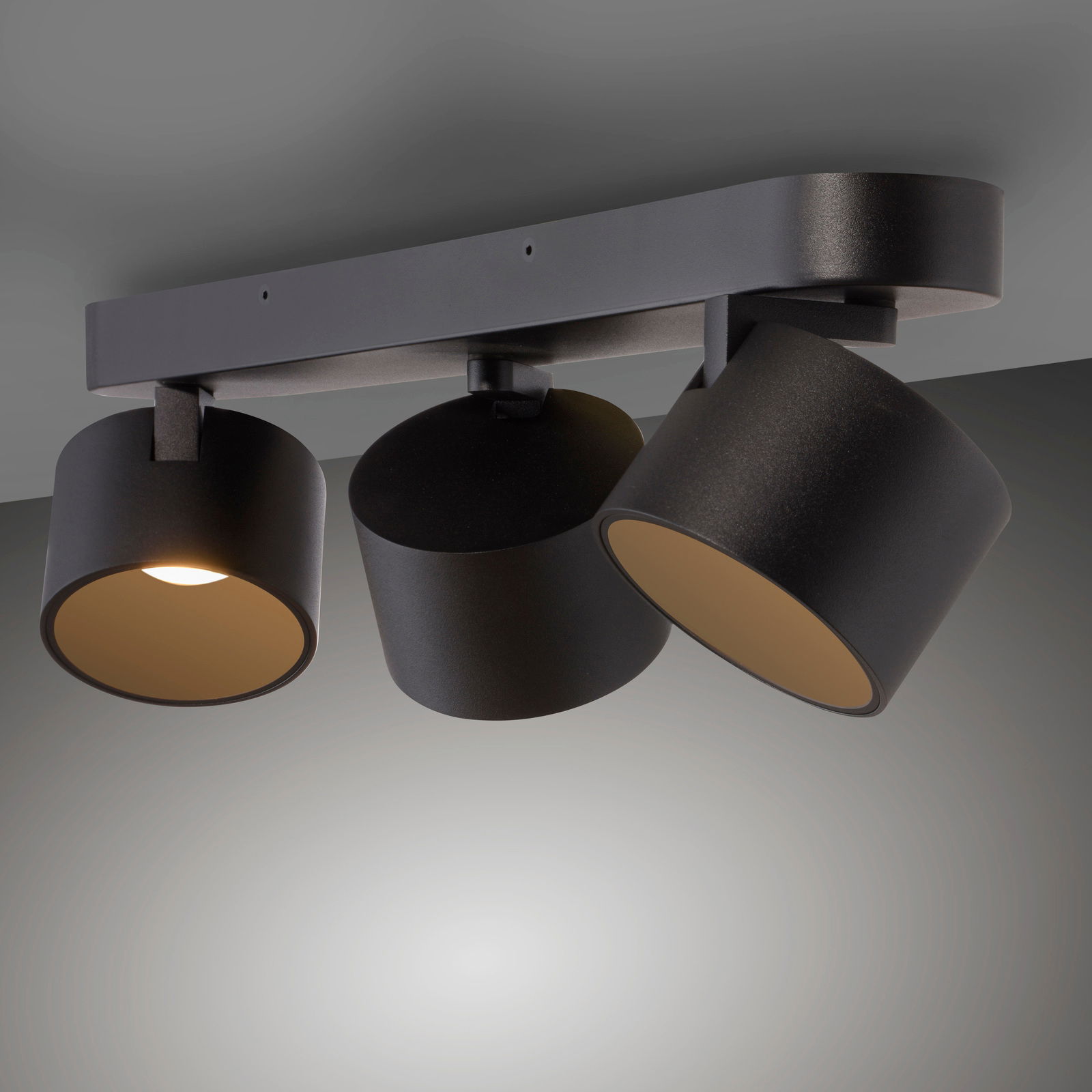 Dreifacher LED-Spot in schwarzem Design, an der Decke montiert, mit verstellbaren Leuchten aus seitlicher Perspektive.