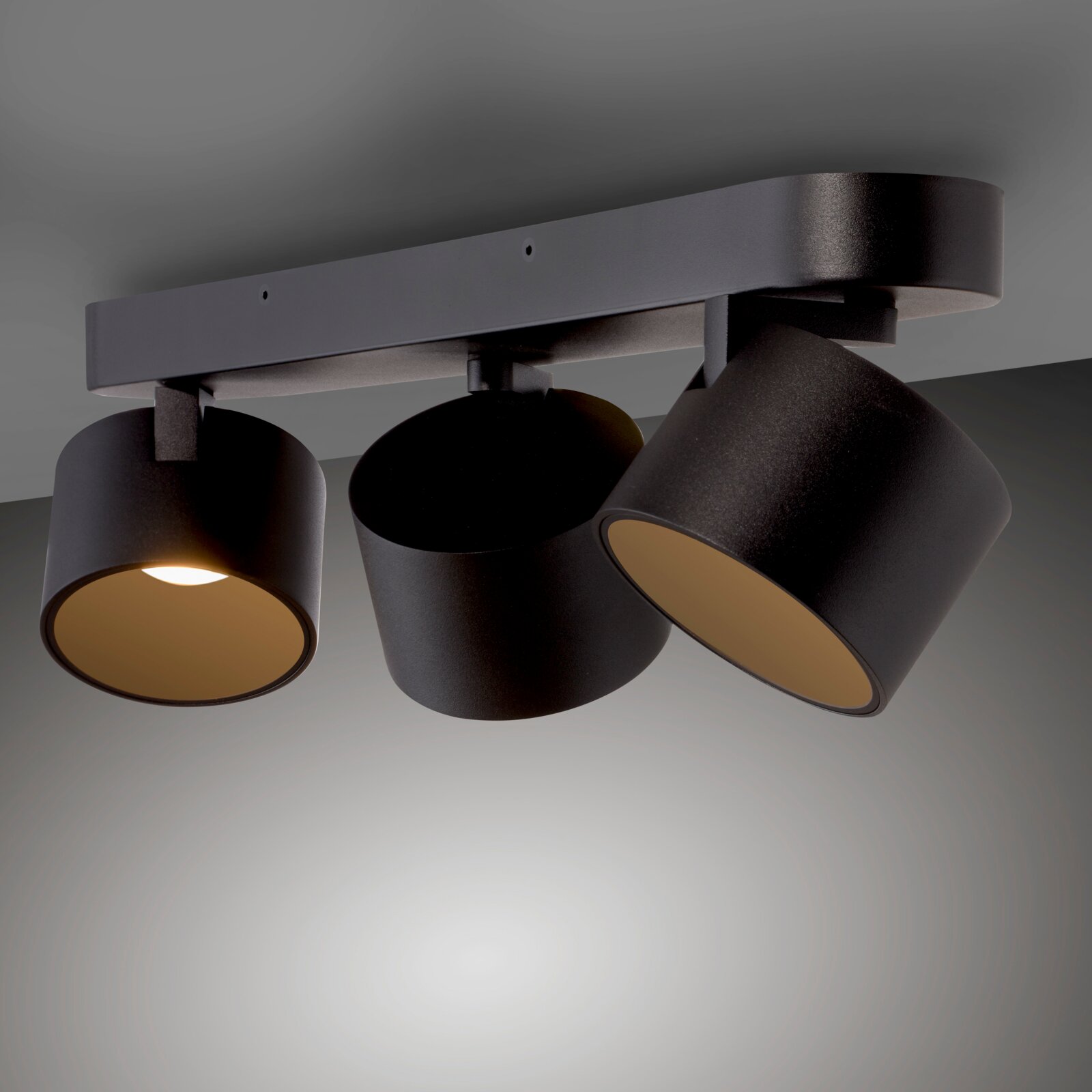 Dreifacher LED-Spot in schwarzem Design, an der Decke montiert, mit verstellbaren Leuchten aus seitlicher Perspektive.