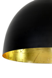 Nahaufnahme einer modernen Hängeleuchte mit schwarzer Außenseite und goldener Innenseite, seitliche Perspektive.