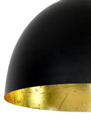 Nahaufnahme einer modernen Hängeleuchte mit schwarzer Außenseite und goldener Innenseite, seitliche Perspektive.