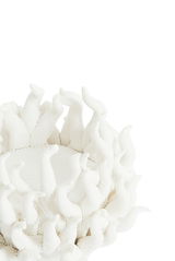 Nahaufnahme eines weißen Teelichthalters mit organischen, flammenartigen Strukturen, von oben betrachtet.