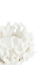 Nahaufnahme eines weißen Teelichthalters mit organischen, flammenartigen Strukturen, von oben betrachtet.