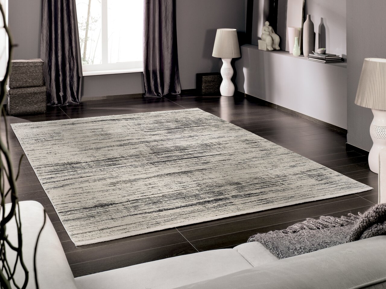 Moderner Designer Teppich in einem stilvollen Wohnzimmer, aus der Perspektive eines Sofas fotografiert.