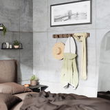 Wandgarderobe aus Holz mit Haken, an der ein Hut, ein Mantel und ein Schal hängen, in einem modernen Schlafzimmer mit Betonwänden, seitliche Perspektive.