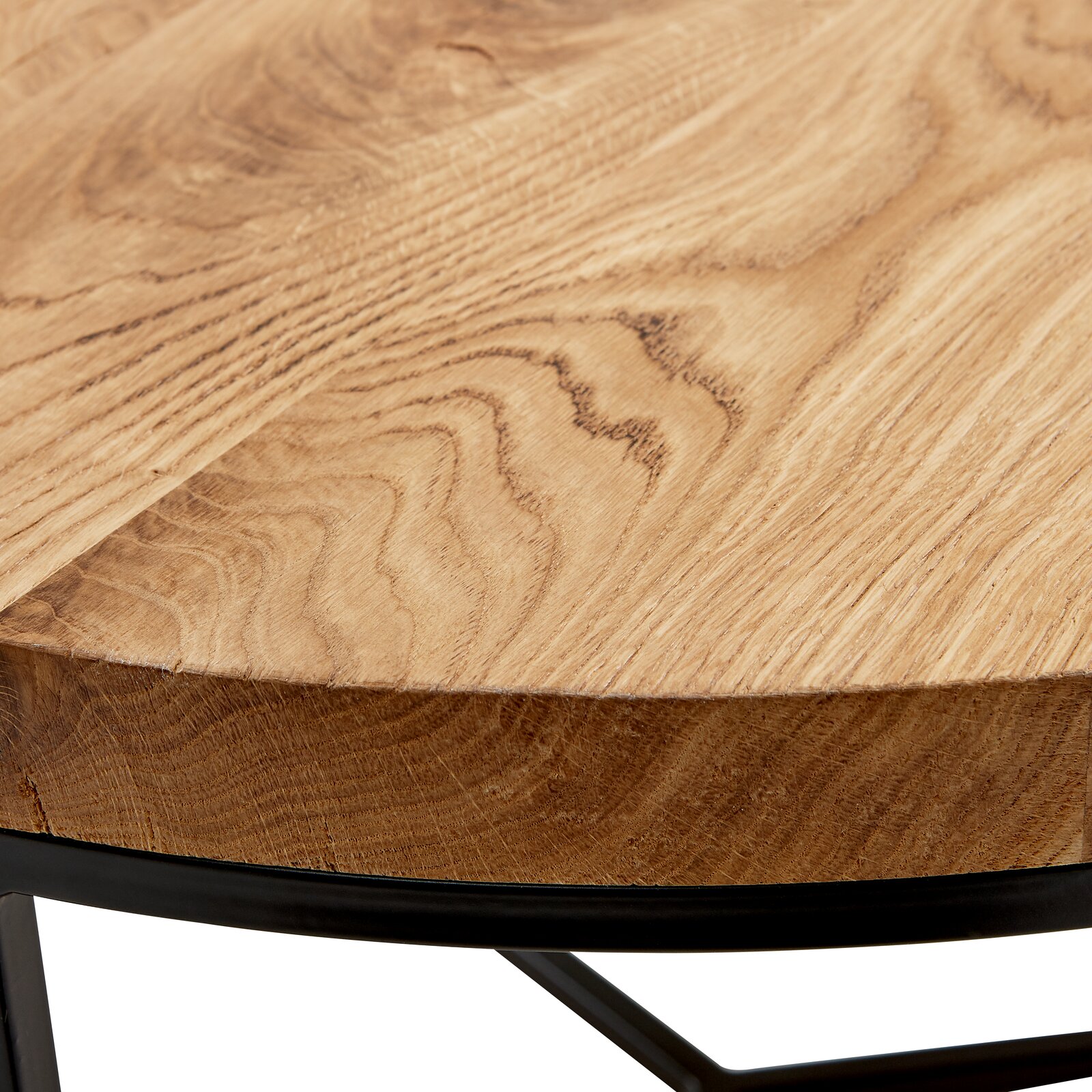 Nahaufnahme eines runden Couchtisches mit einer Holzplatte und einem schwarzen Metallgestell, seitliche Perspektive