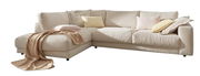 Beige Ecksofa mit weichen Kissen und Decke, seitliche Perspektive