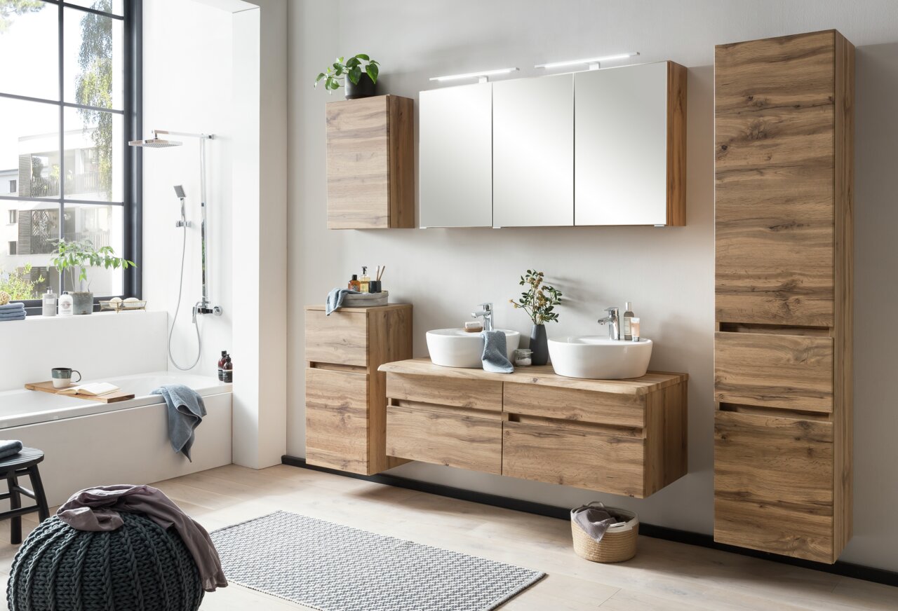 Moderner Spiegelschrank in einem stilvollen Badezimmer mit Holzschränken und Doppelwaschbecken, seitliche Perspektive