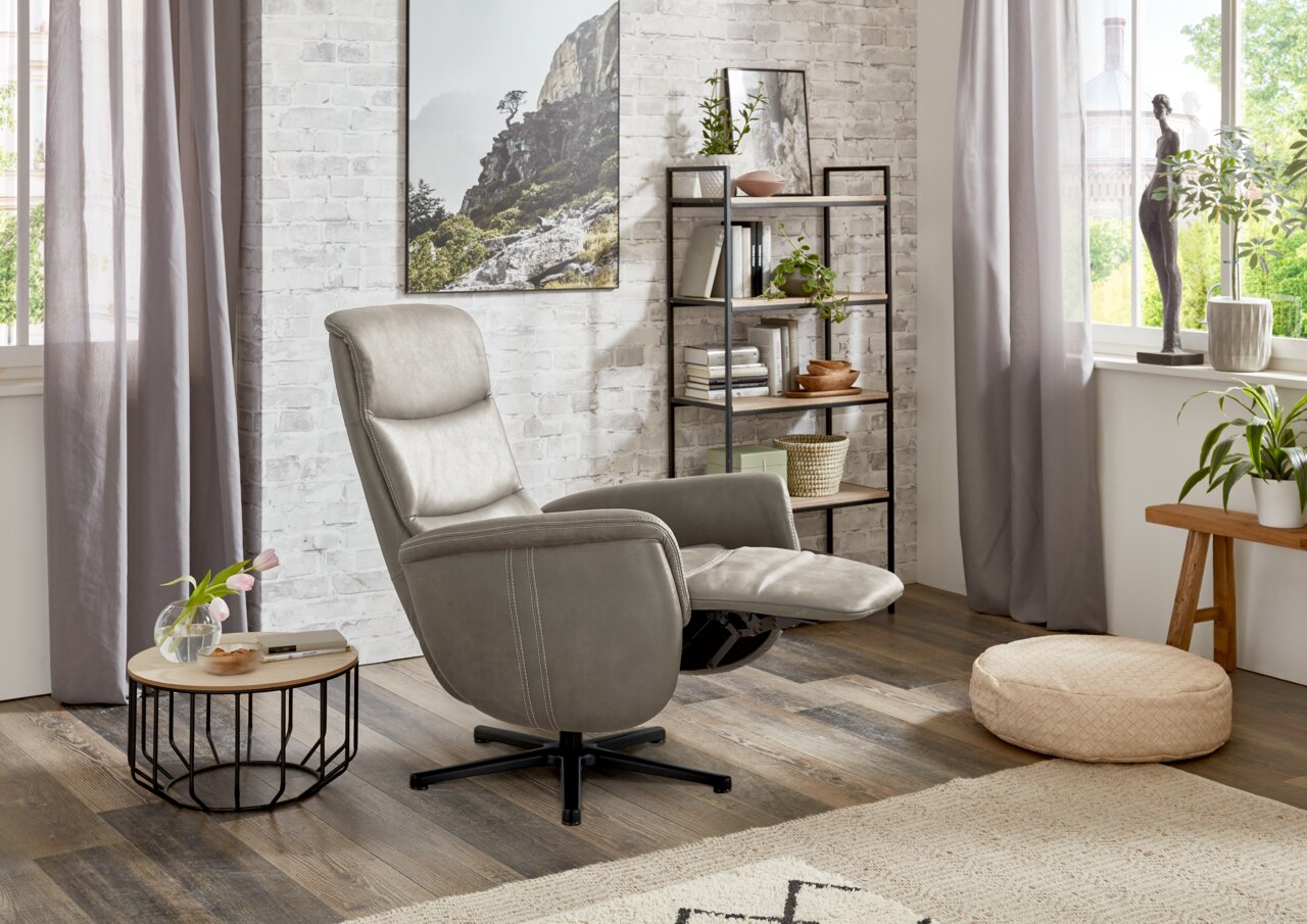 Grijze relaxfauteuil in een gezellige woonkamer, zijaanzicht