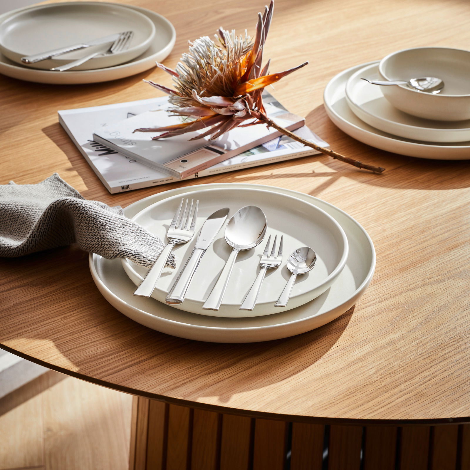 Elegantes 60-teiliges Besteckset Philadelphia auf einem gedeckten Tisch, aus der Vogelperspektive fotografiert.