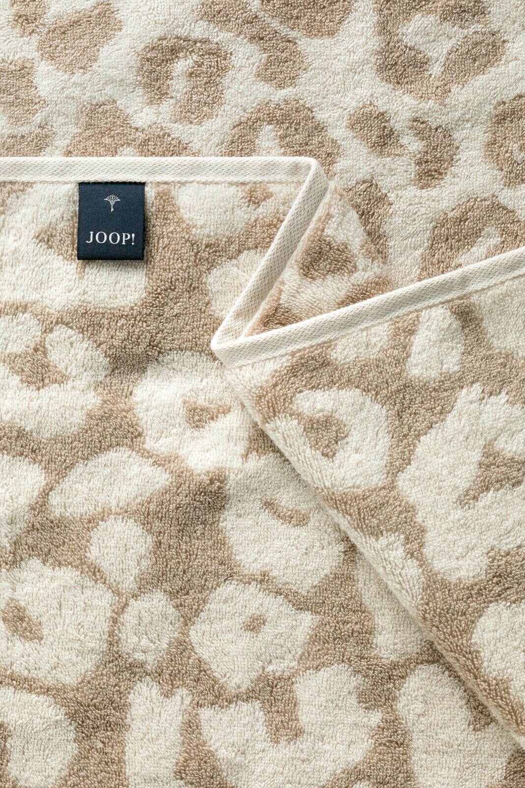 Nahaufnahme eines beigen Saunatuchs mit floralem Muster und einem Joop-Label.