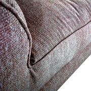 Close-up van een Big Sofa ROMANTICO met gestructureerde stoffen bekleding, gezien vanuit een zijdelingse hoek.