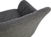 Nahaufnahme eines grauen, gepolsterten Stoffsessels mit strukturierter Armlehne und gestepptem Rückenpolster, seitliche Perspektive