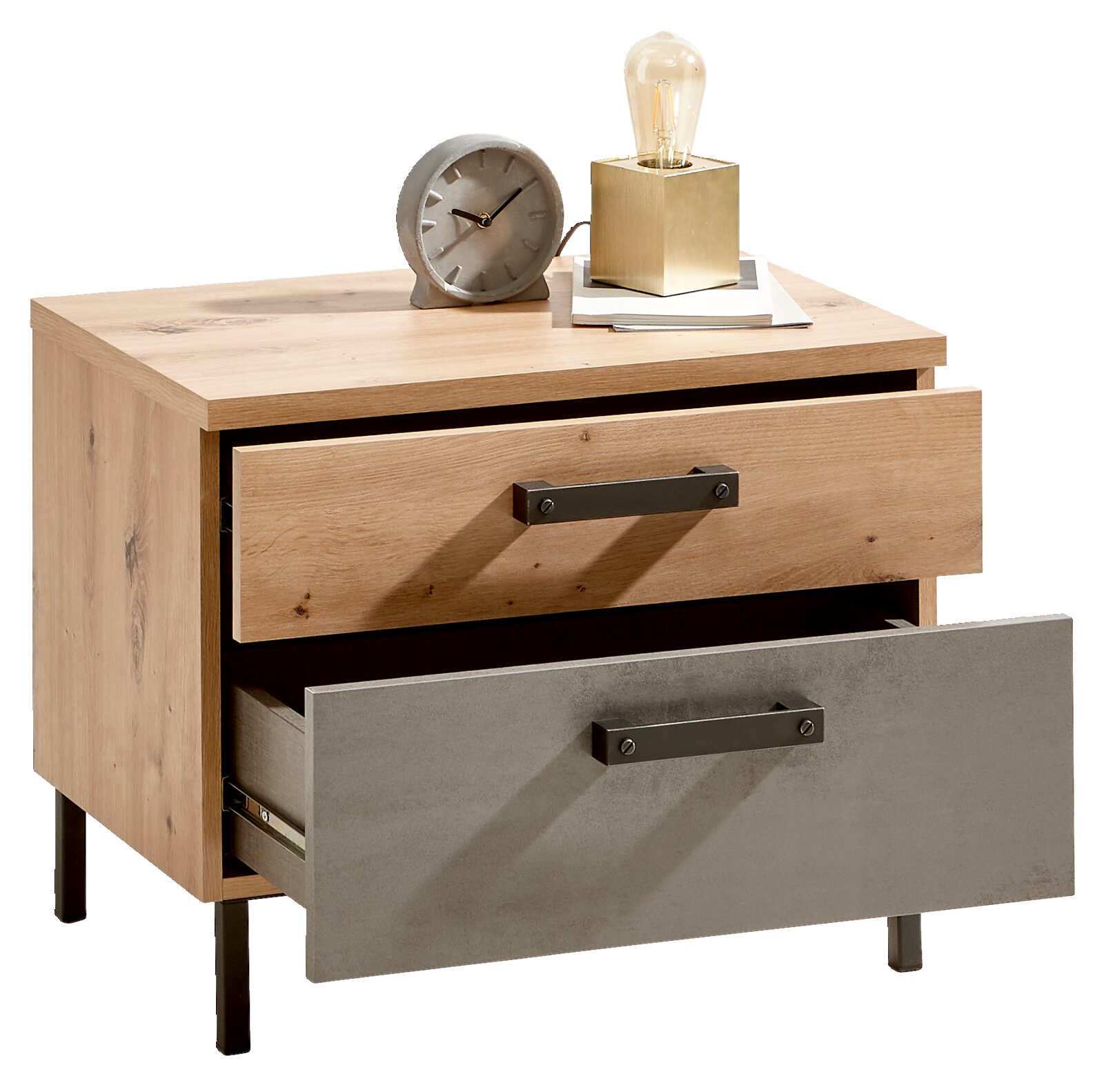 Nachtkommode aus Holz mit zwei Schubladen, eine in Holzoptik und eine in Betonoptik, mit schwarzem Griff. Auf der Kommode stehen eine Uhr und eine Lampe. Perspektive: Frontalansicht.